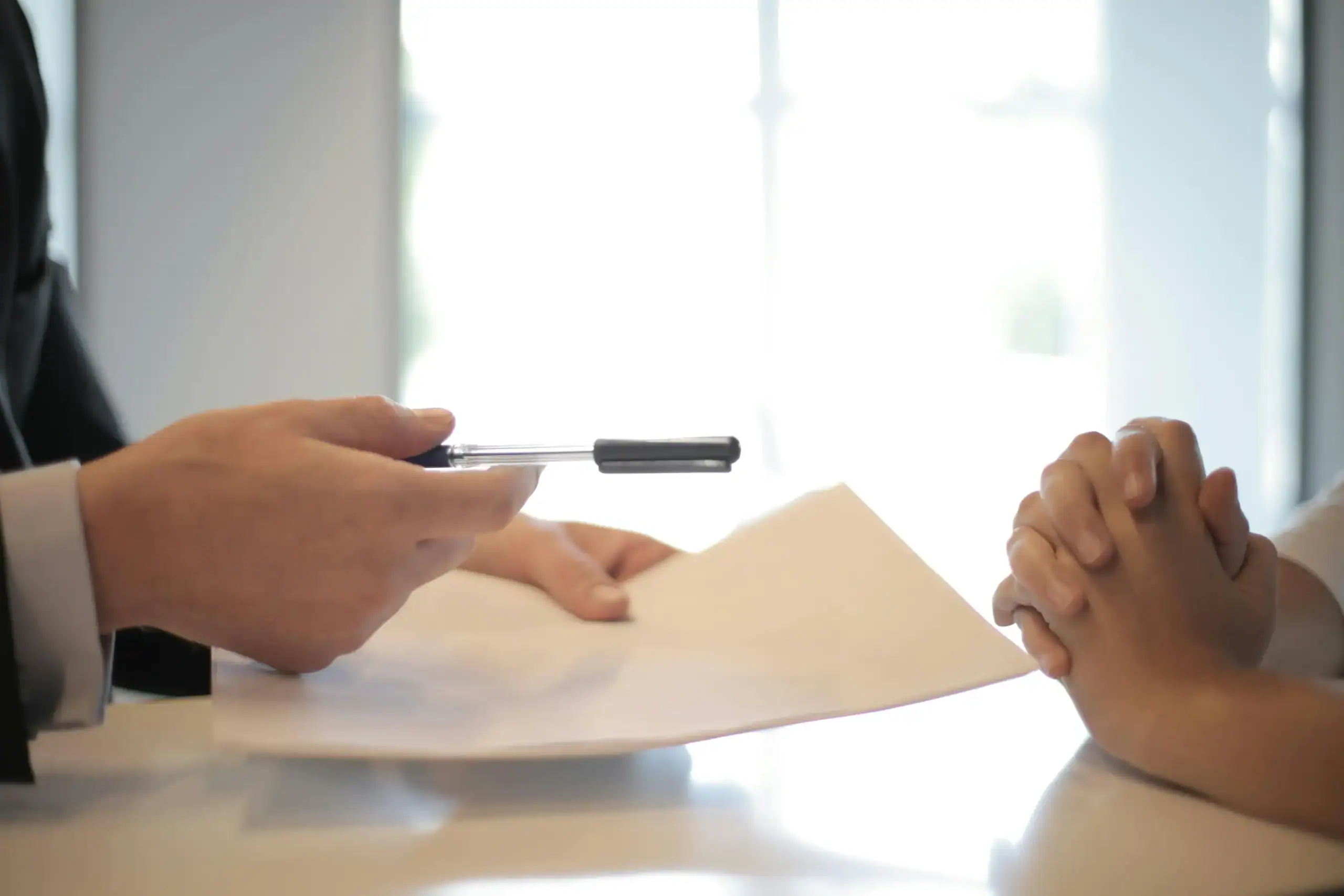 man holding pen and paper during a meeting