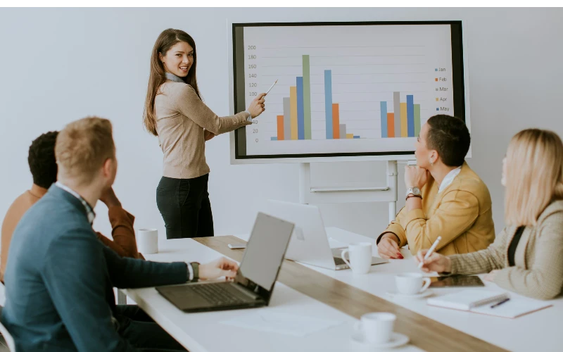 woman presenting in front of the team